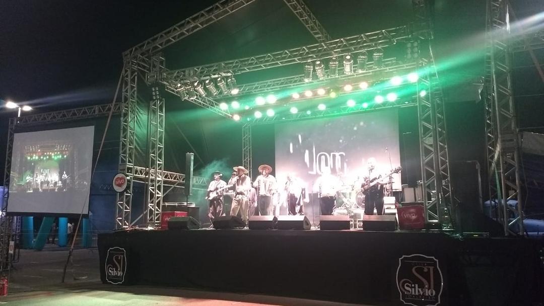 Palco montado com iluminação cênica durante show noturno